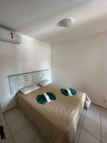 a bedroom with a bed with two towels on it at Villaggio Boccia in Bertioga