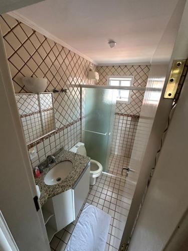 a bathroom with a sink and a shower and a toilet at Villaggio Boccia in Bertioga