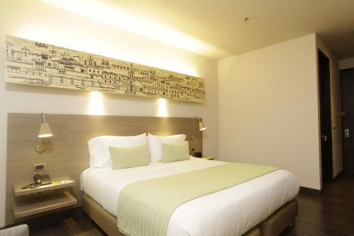 a hotel room with a large bed and a sign on the wall at Hotel bh Usaquén in Bogotá