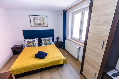 a bedroom with a yellow bed with a yellow blanket at Planetarium - Stare Miasto, Parking Free in Toruń