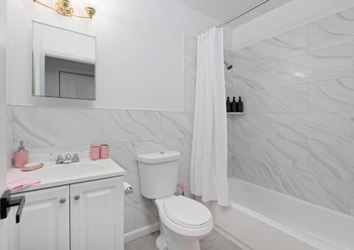 ユニオンシティにあるRose Stay, Stylish 2BR Apartment - Sleeps 6 - 25 Min to NYCのトイレと浴槽を備えた白いバスルーム