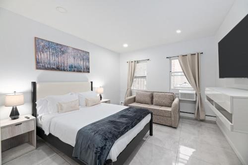 ユニオンシティにあるRose Stay, Stylish 2BR Apartment - Sleeps 6 - 25 Min to NYCのベッドと椅子のある白い寝室