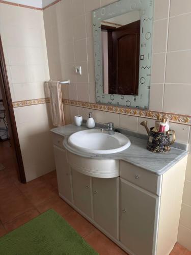 a bathroom with a sink and a mirror at Refúgio das Alfazemas in Vila Nova de Milfontes