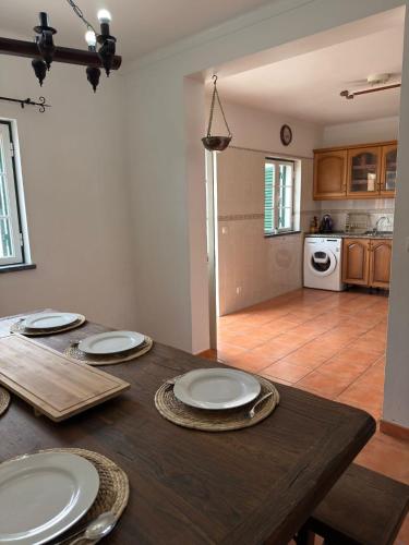 a wooden table with plates on it in a kitchen at Refúgio das Alfazemas in Vila Nova de Milfontes