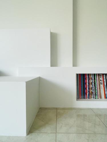a white wall with a book shelf filled with books at Studiò in Termoli