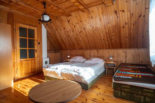 a bedroom with a bed in a wooden room at Domek nad jeziorem in Kretowiny