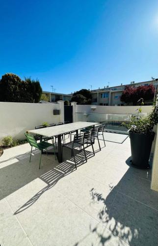 - une table de pique-nique et des chaises sur la terrasse dans l'établissement Villa calme avec piscine, Montpellier city center, à Montpellier