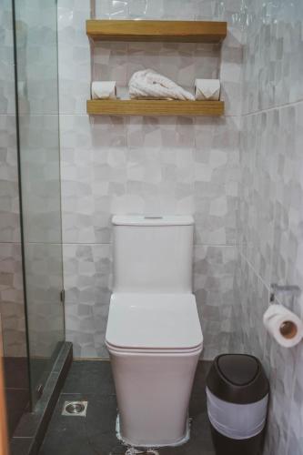 a bathroom with a white toilet and a shelf at Elite Maya Hotel & Spa in Antigua Guatemala
