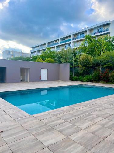 une piscine devant un immeuble dans l'établissement La douceur Cannoise soit un 2P cosy terrasse piscine vue jardin proche plage à pied, à Cannes