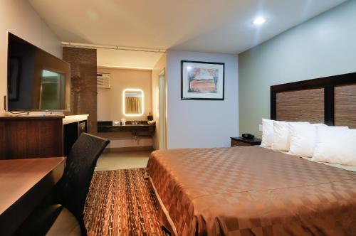 a hotel room with a bed and a desk at Vagabond Inn Sunnyvale in Sunnyvale