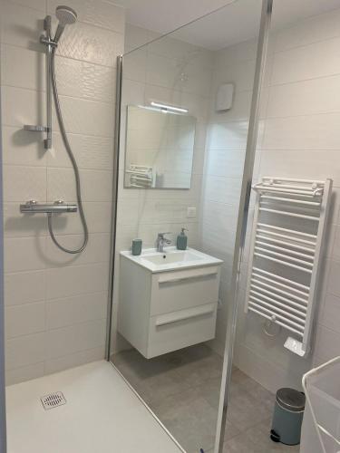 a white bathroom with a sink and a shower at L Etape Châtillonnaise center private parking in Châtillon-sur-Chalaronne