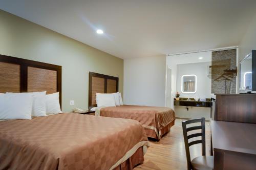 a hotel room with two beds and a kitchen at Vagabond Inn Sunnyvale in Sunnyvale