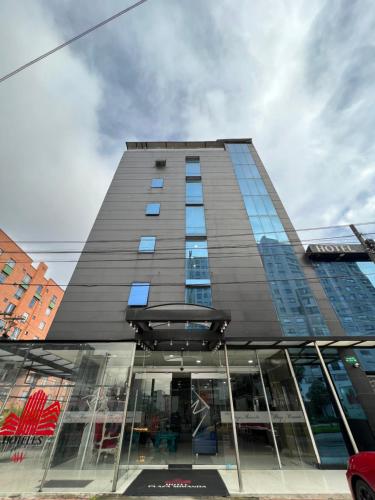 a tall building with a glass entry way at Hotel Plaza Sport in Bogotá