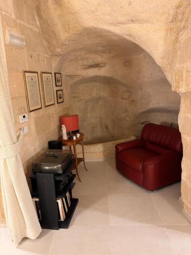 a living room with a red couch and a table at Casa Grotta Francy - Piazza San Giovanni in Matera