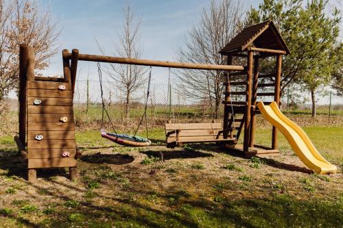 un parque infantil con un columpio y un tobogán y un tobogán en Wilkiejmy wieś ma wzgórzu, en Wilkiejmy