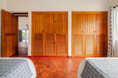 a bedroom with two beds and wooden cabinets at Casa en Cerritos con Piscina y 4 habitaciones in Pereira