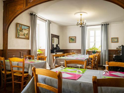 une salle à manger avec tables et chaises et un lustre dans l'établissement Gîte Zelai Begi, à Aldudes