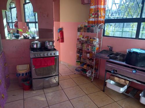 a kitchen with a stove with pots and pans on it at Casa Huespedes El Molino in Tababela