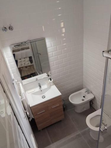 a white bathroom with a sink and a toilet at Ático Sol & Mar - La Línea in La Línea de la Concepción