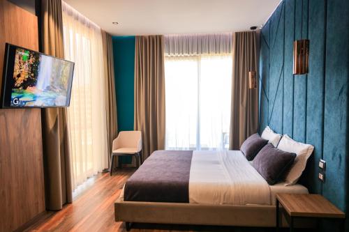 a hotel room with a bed and a tv at Hotel Apollon Sarande in Sarandë