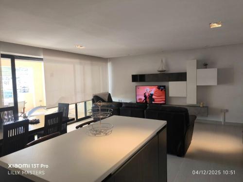 a living room with a table and chairs and a tv at Theo's Court Sea View in Marsalforn