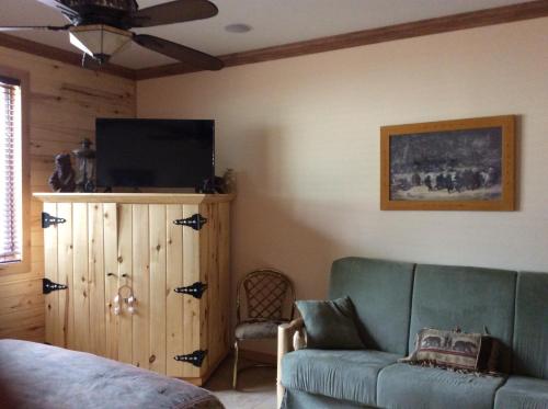 a living room with a couch and a flat screen tv at Elktrace Bed and Breakfast in Pagosa Springs