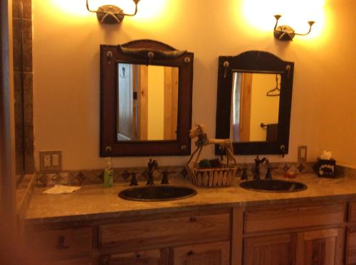 a bathroom with two sinks and two mirrors at Elktrace Bed and Breakfast in Pagosa Springs