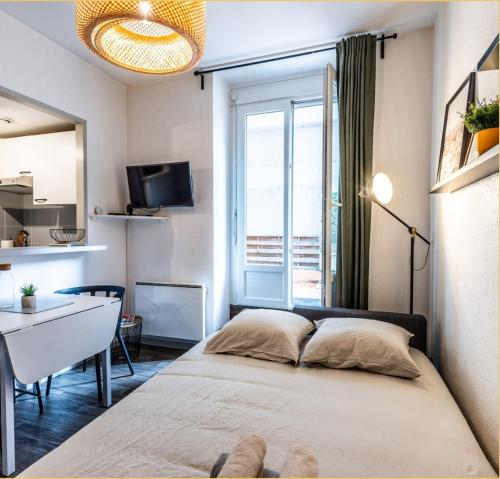 une chambre avec un lit, un bureau et une fenêtre dans l'établissement T2 centre ville, 150m du lac, parking - Thermes, à Évian-les-Bains