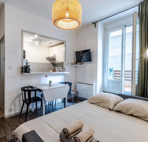 une chambre avec un lit, une table et une fenêtre dans l'établissement T2 centre ville, 150m du lac, parking - Thermes, à Évian-les-Bains