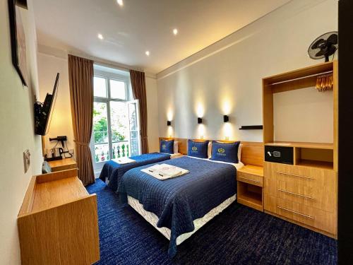 Una habitación de hotel con dos camas y un televisor. en Jubilee Hotel Victoria, en Londres