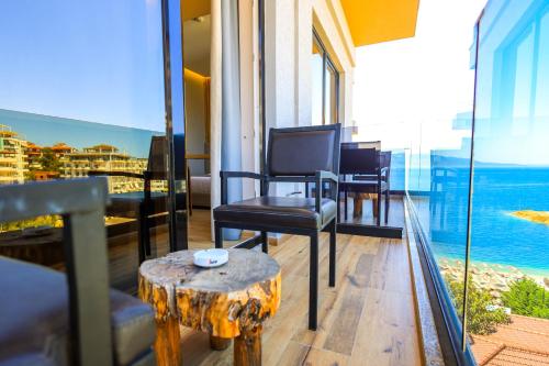 a room with a table and chairs on a balcony at Hotel Apollon Sarande in Sarandë