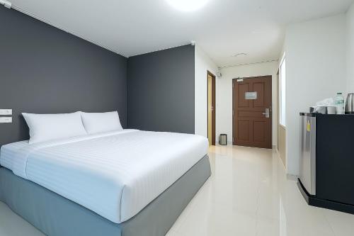 a bedroom with a white bed and a blue wall at Siam Rama9 Hotel in Amphoe Phra Khanong