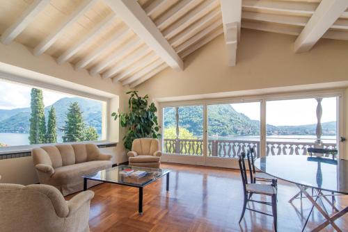 a living room with a table and chairs and a balcony at Villa Belvedere by Comorooms in Como