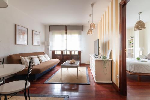 a living room with a couch and a table at La Campanilla de Cabárceno in Sarón