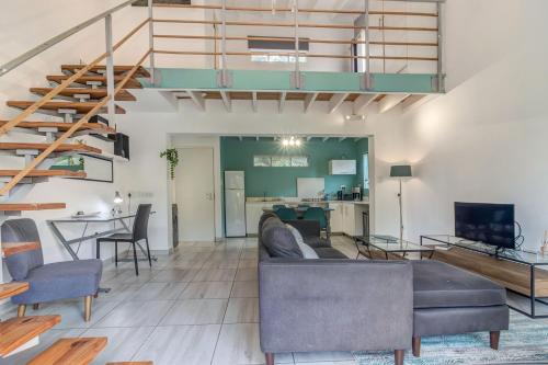 a living room with a couch and a staircase at Sitatunga Guest Lodge in Johannesburg