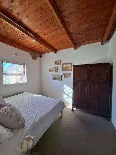 a bedroom with a bed and a wooden ceiling at Whitehouse- Hot Tub in Elands Bay
