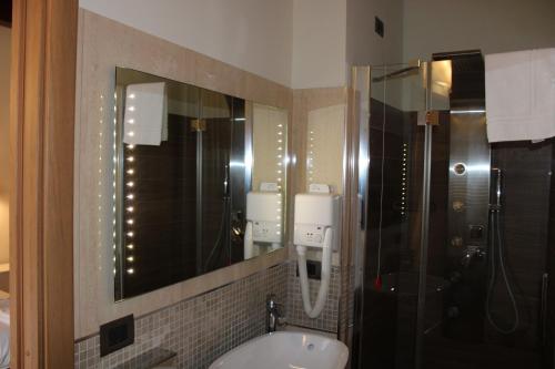 a bathroom with a sink and a shower and a mirror at Il Borgo Ospitale - Albergo Diffuso in Rotonda