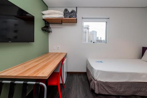 a room with a bed and a desk with a television at ibis Styles Belem Nazare in Belém