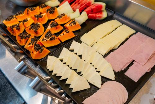 a tray with different types of cheese and fruit at ibis Styles Belem Nazare in Belém