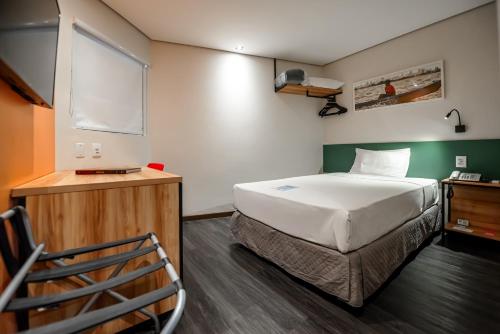 a room with a bed and a chair in it at ibis Styles Belem Nazare in Belém