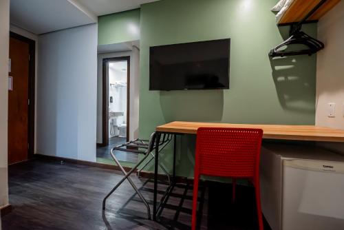 a kitchen with a table and a red chair at ibis Styles Belem Nazare in Belém
