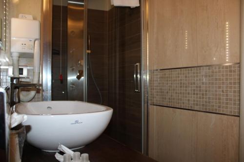 a bathroom with a white tub and a glass door at Il Borgo Ospitale - Albergo Diffuso in Rotonda