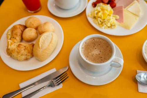 a table with plates of food and a cup of coffee at ibis Styles Belem Nazare in Belém