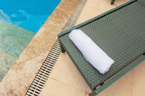 a white towel sitting on a table next to a swimming pool at ibis Styles Belem Nazare in Belém
