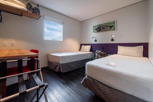 a hotel room with two beds and a desk at ibis Styles Belem Nazare in Belém