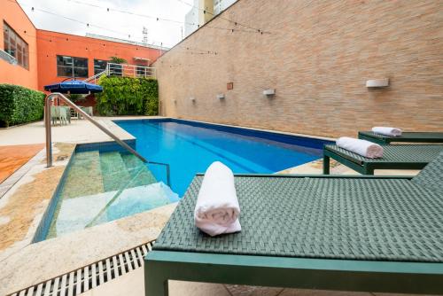 a towel sitting on a table next to a swimming pool at ibis Styles Belem Nazare in Belém