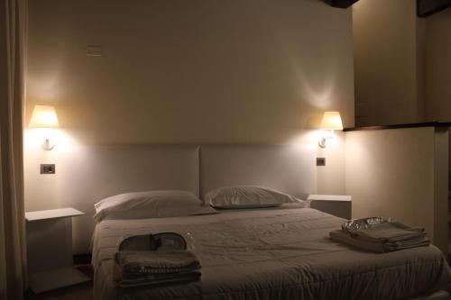 a bedroom with a bed with two lights on it at Il Borgo Ospitale - Albergo Diffuso in Rotonda