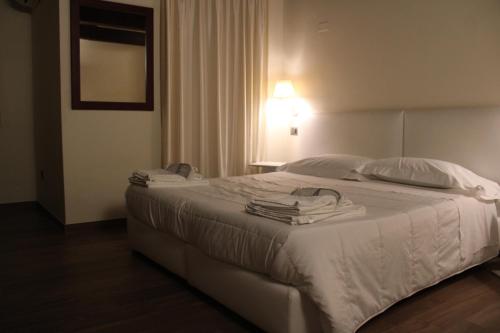 a bedroom with a bed with white sheets and pillows at Il Borgo Ospitale - Albergo Diffuso in Rotonda