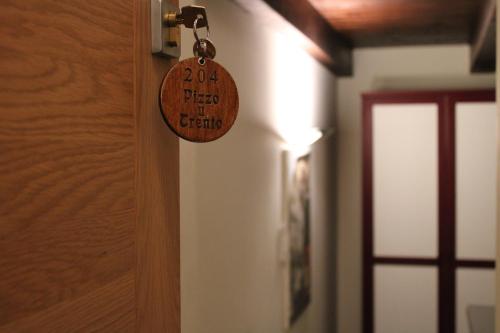 a wooden door tag hanging on a wall at Il Borgo Ospitale - Albergo Diffuso in Rotonda