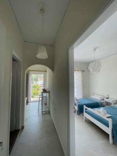 a bedroom with a bed and a room with a hallway at Rois Appartments in Poros